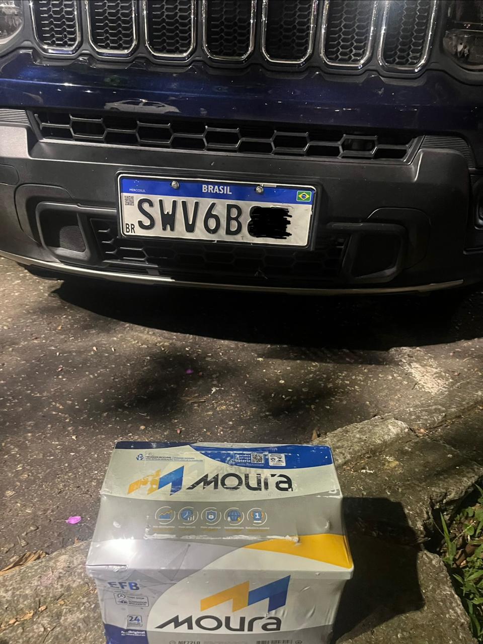 Bateria automotiva nova ao lado de veículo atendido