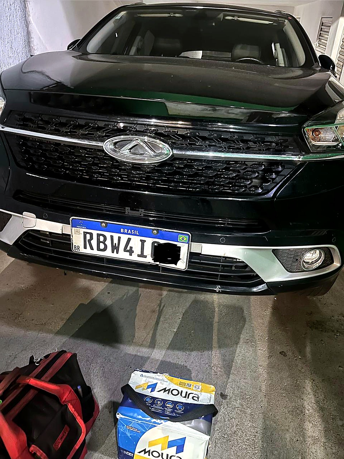 Atendimento de bateria automotiva em SUV em garagem